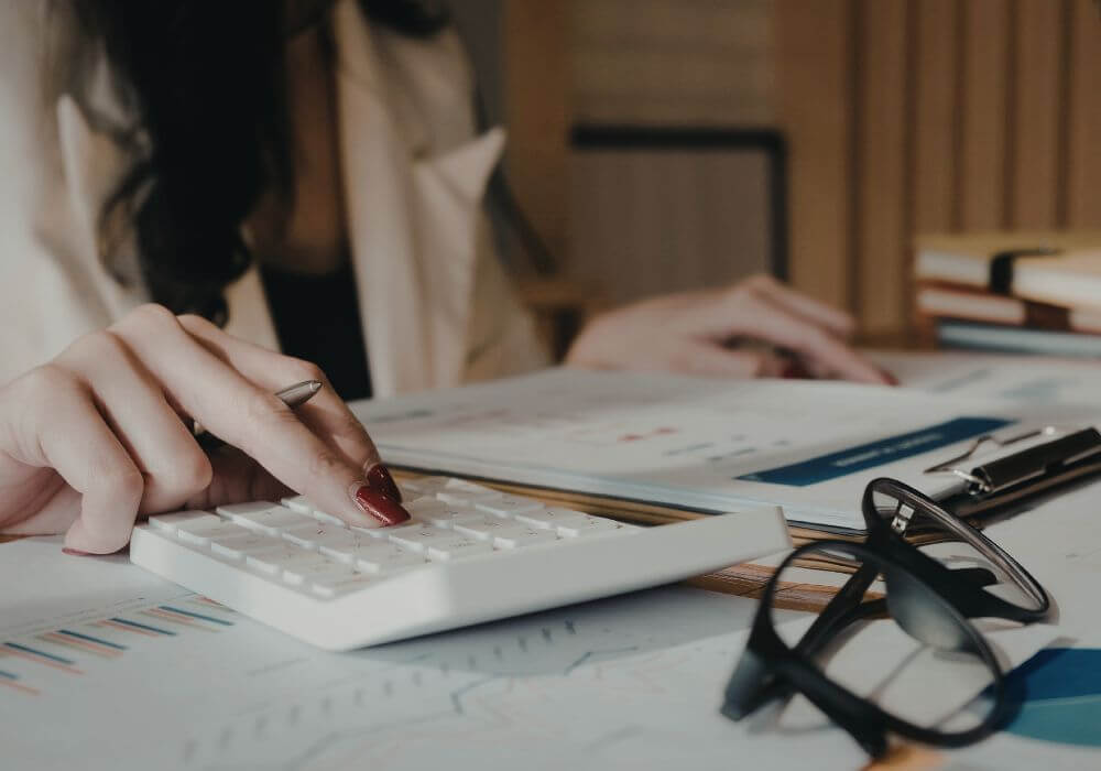 Image of person looking at documents with a calculator, representing article on Make Work Pay umbrella consultation and impact on recruitment agencies