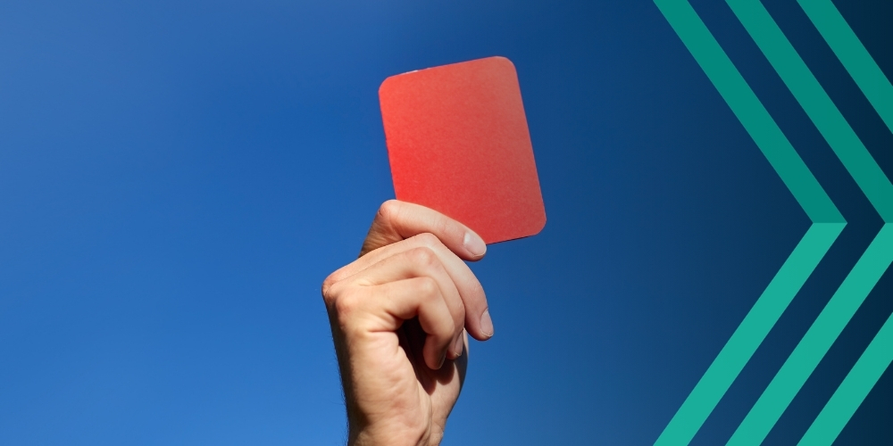 Hand holding up red card, representing article on PGMOL v HMRC IR35 appeal win