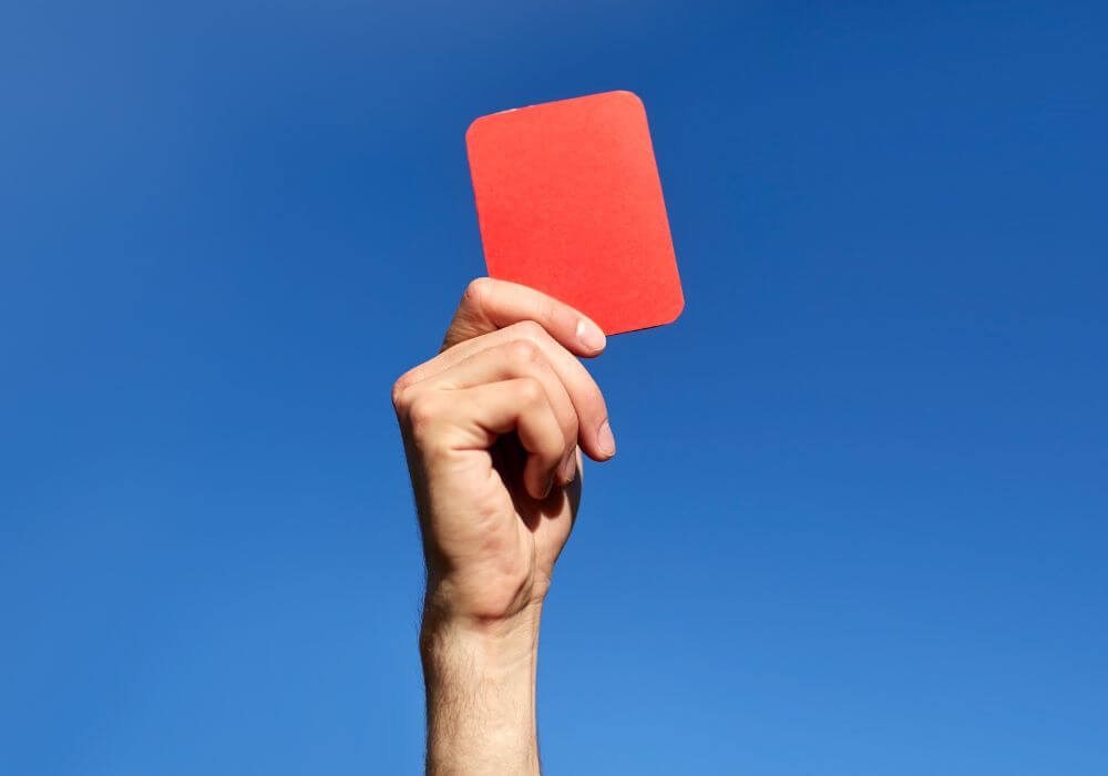 Hand holding up red card, representing article on PGMOL v HMRC IR35 appeal win