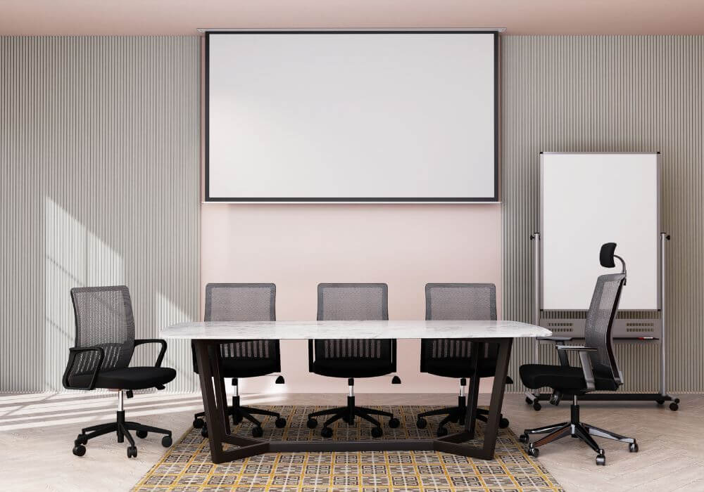 Image of empty white meeting room with table and office chairs. Representing article on what management liability is for recruiters